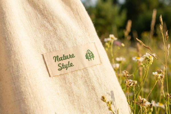 Etiqueta de algodón natural con texto verde en bolsa de tela