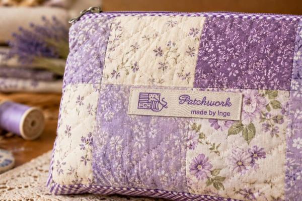Etiqueta de algodón natural con texto lila en bolso patchwork
